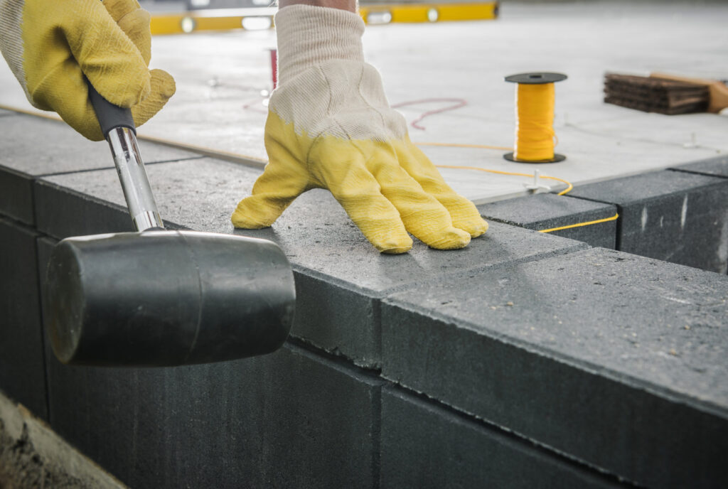 Worker Levelling Patio Concrete Floor Bricks Close Up